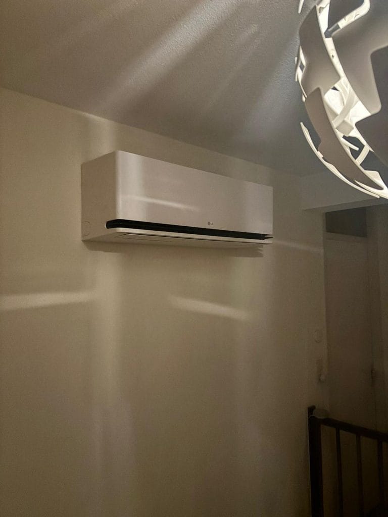 Airconditioner aan muur naast witte lamp