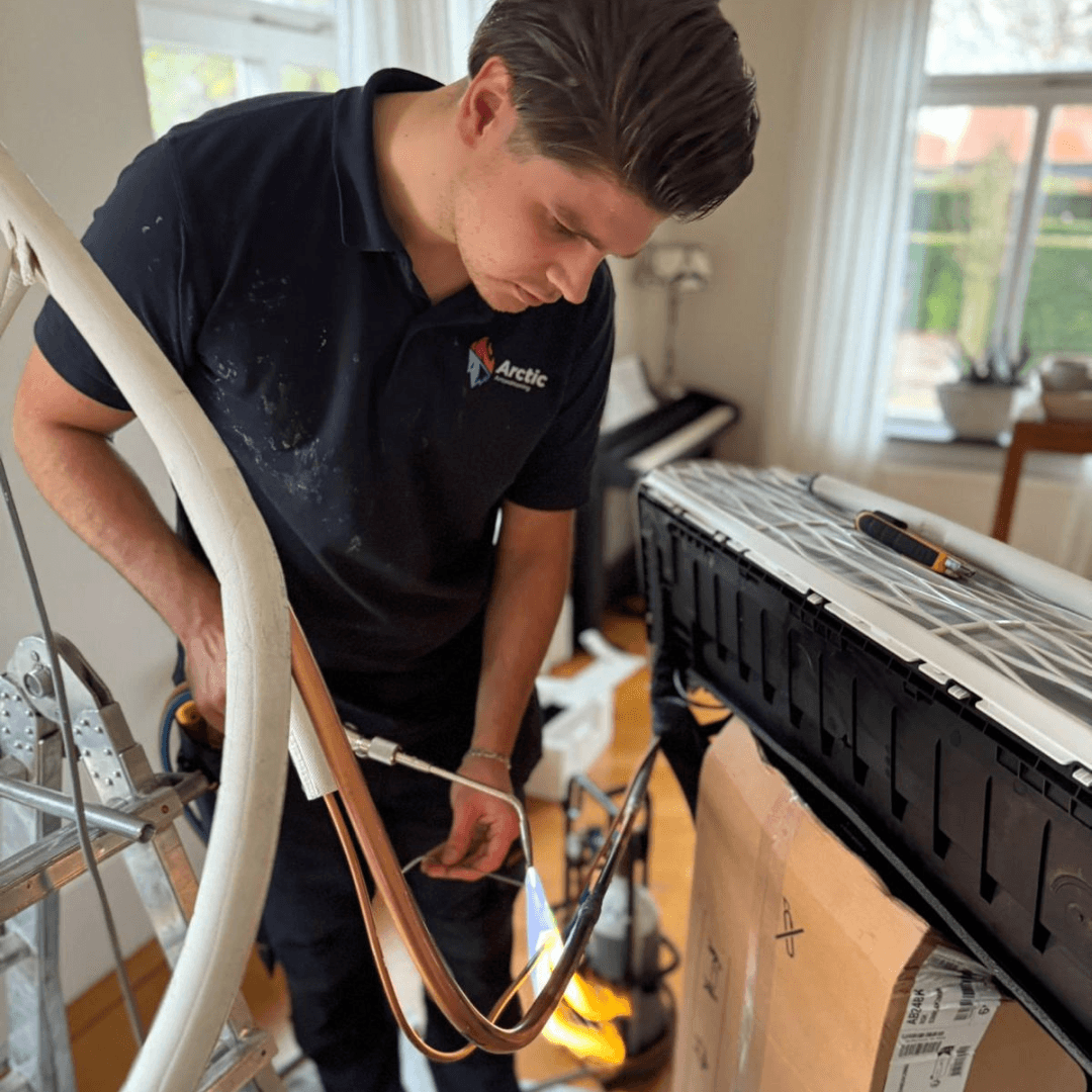 Technicus repareert airconditioning in woonkamer